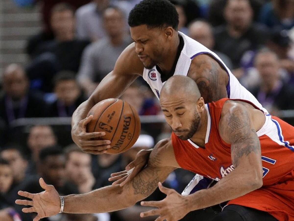 Clippers guard Dahntay Jones dives for a loose ball as Kings forward Rudy Gay grabs it.