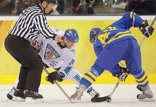 Sweden's Henrik Zetterberg (R) and Finland's Niko Kapanen fight for the puck.