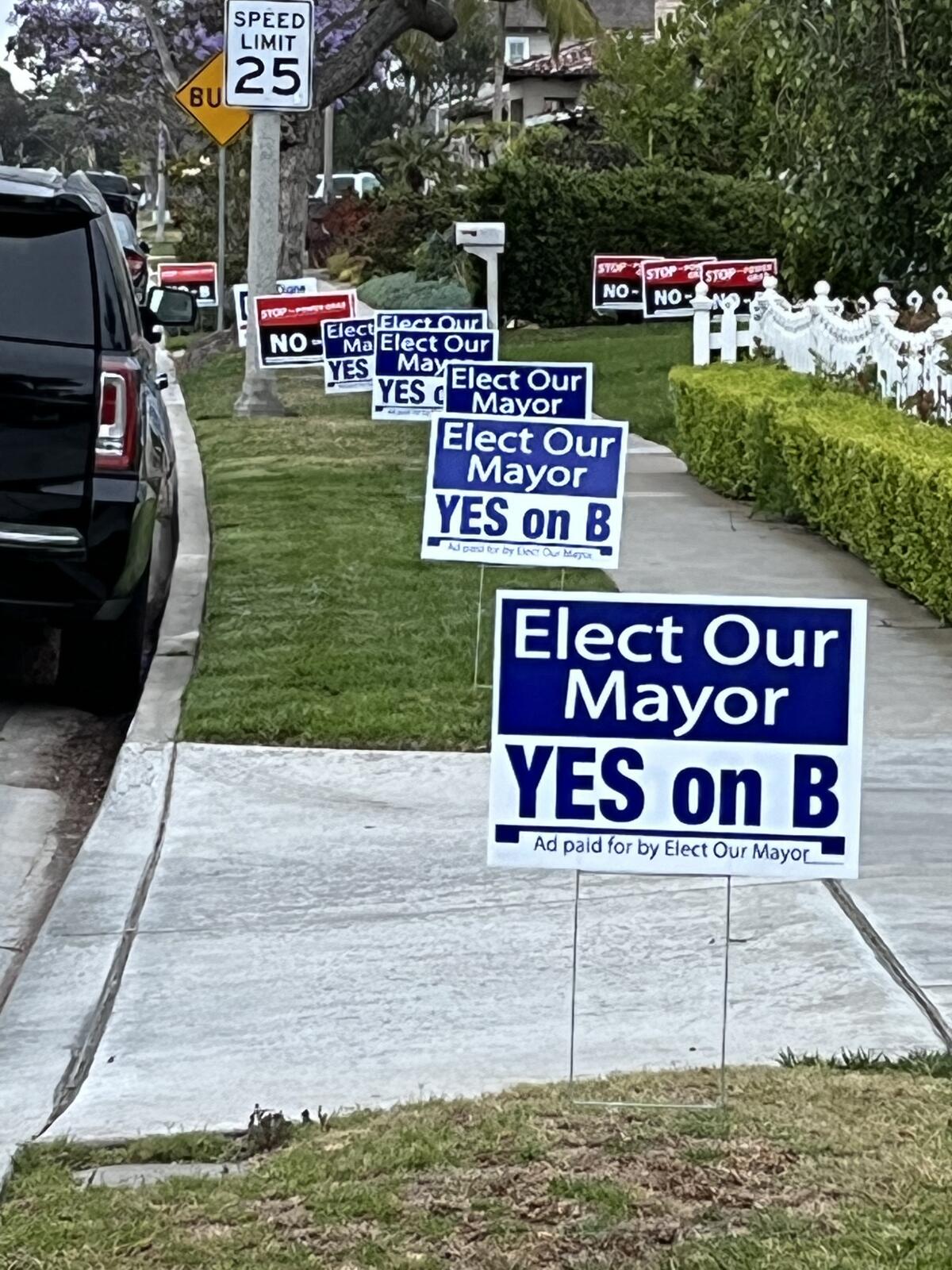 Along Mariners Drive, signs in support and against Measure B line the street a day before Election Day.