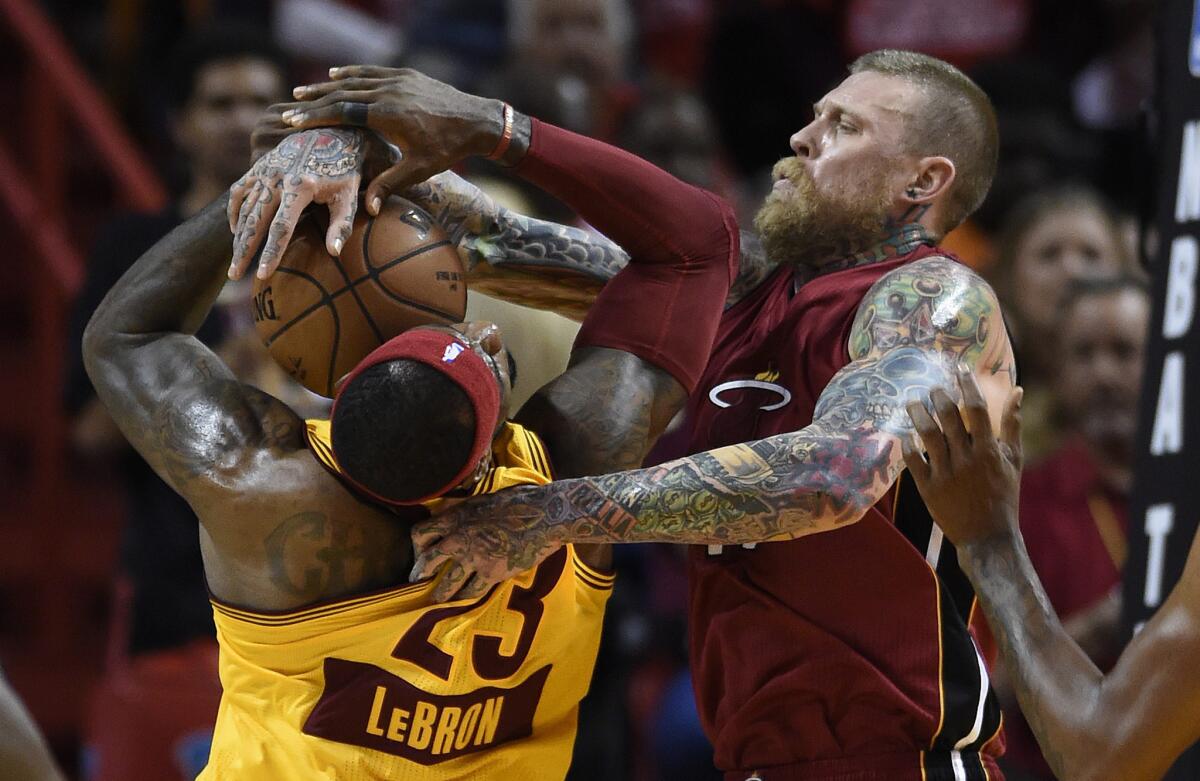 Cavaliers forward LeBron James is clobbered by Heat center Chris Andersen in the first half of their Christmas Day game.