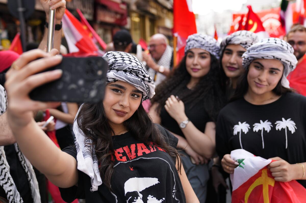 A marcher in a Che Guevara shirt takes a selfie with others.