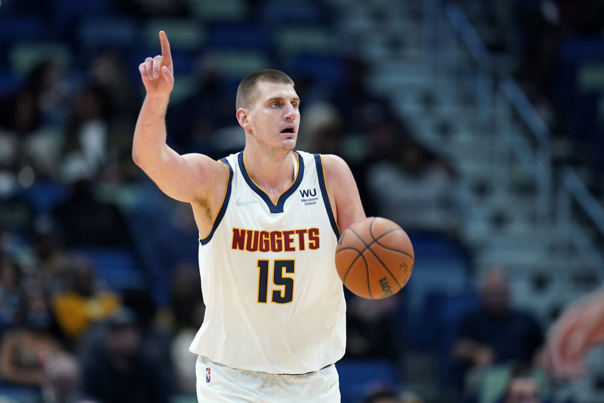 Denver Nuggets center Nikola Jokic (15) moves the ball down court in the first half of an NBA basketball game against the New Orleans Pelicans in New Orleans, Wednesday, Dec. 8, 2021. (AP Photo/Gerald Herbert)