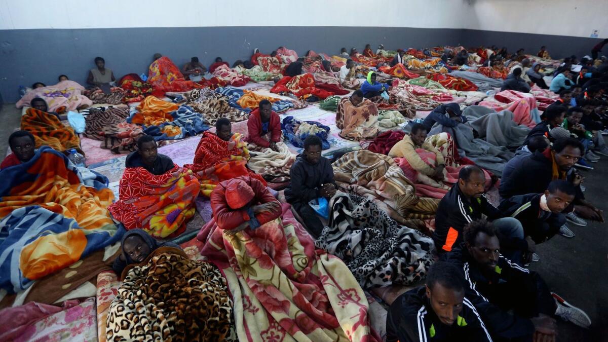 This December file photo shows African migrants sitting in a shelter at the Tariq Al-Matar migrant detention center on the outskirts of the Libyan capital of Tripoli.