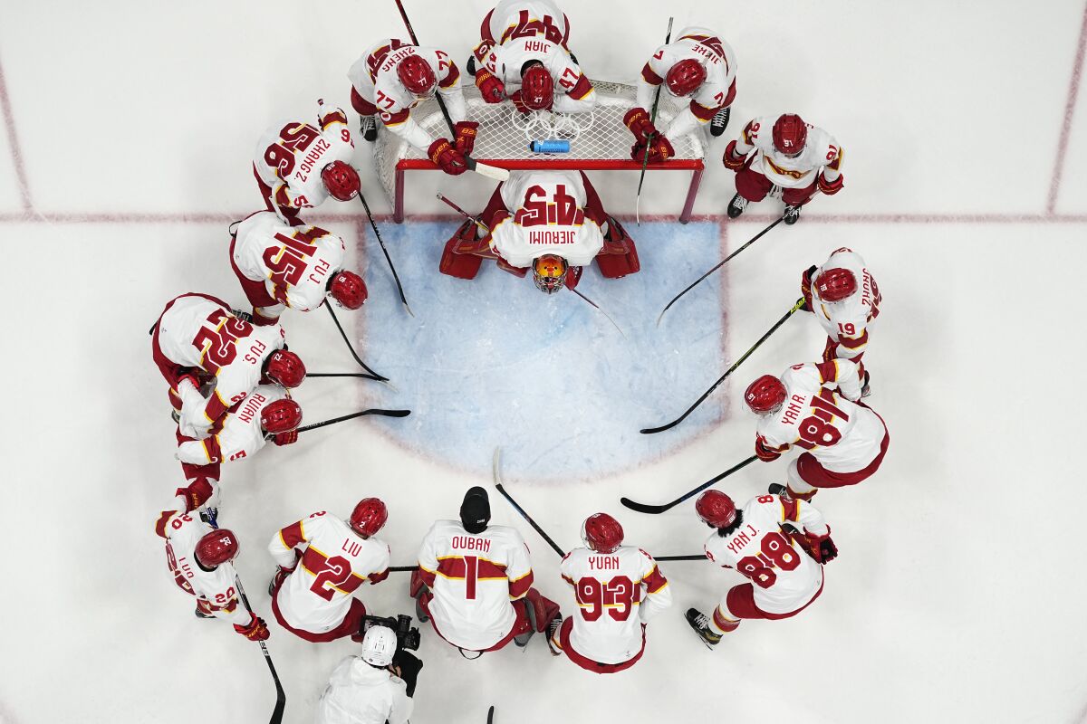Team China players gather before a preliminary round men's hockey game against Germany at the 2022 Winter Olympics, Saturday, Feb. 12, 2022, in Beijing. (AP Photo/Matt Slocum)