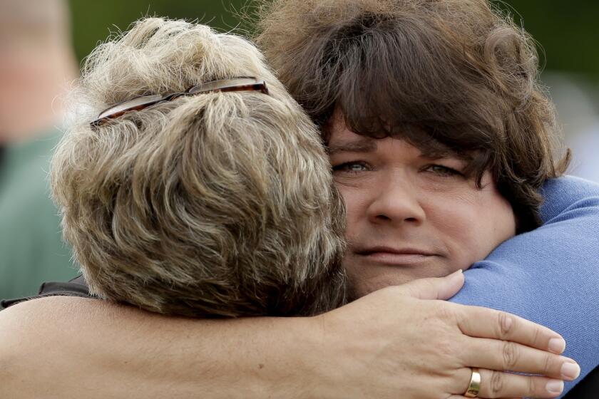 Lisa Crowder, facing camera, is hugged by a friend before a First Baptist Church service held in a field four days after an explosion at a fertilizer plant in West, Texas. Crowder's home was destroyed in the massive explosion.