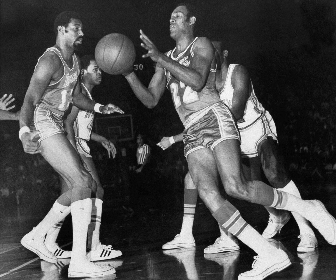 Los Angeles center Wilt Chamberlain, left, passes off to teammate Elgin Baylor (22) who drives in for a layup in first half of National Basketball Association game, January 24, 1969 with the Atlanta Hawks.