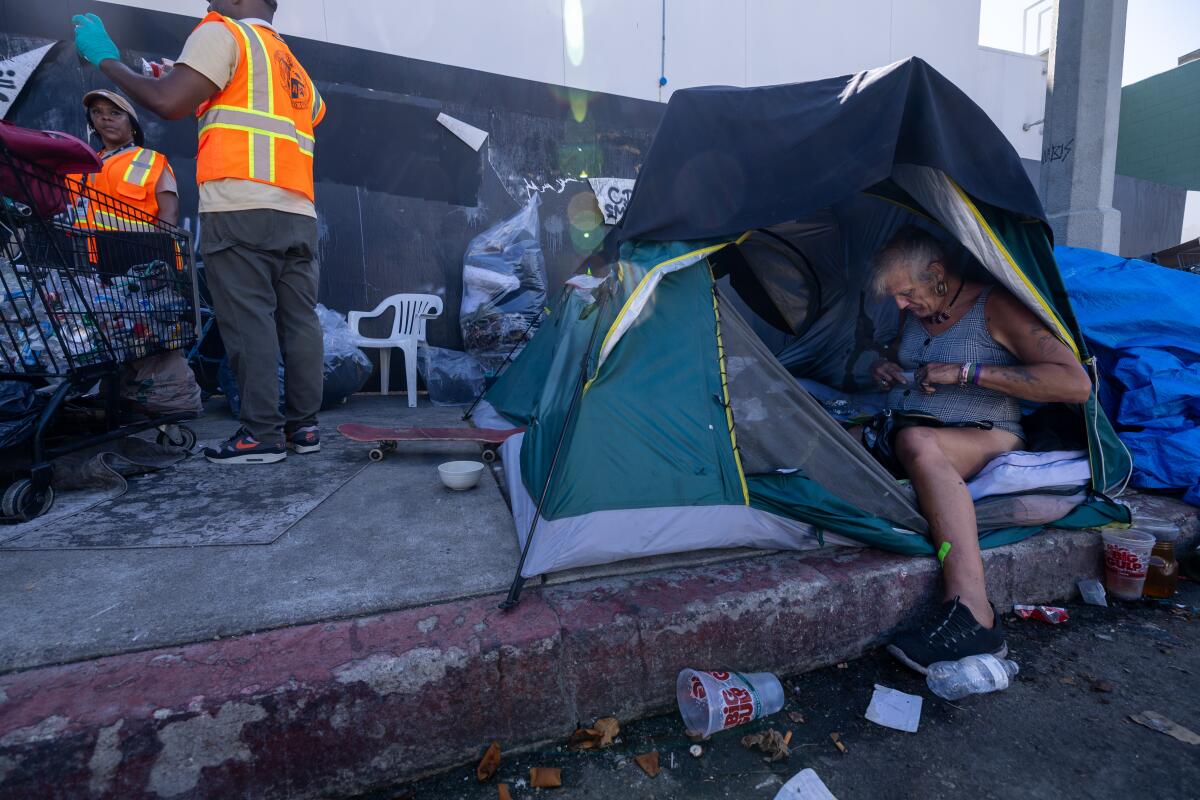 Sherri Oller, right, gathers her belongings at a homeless encampment in Hollywood last August.