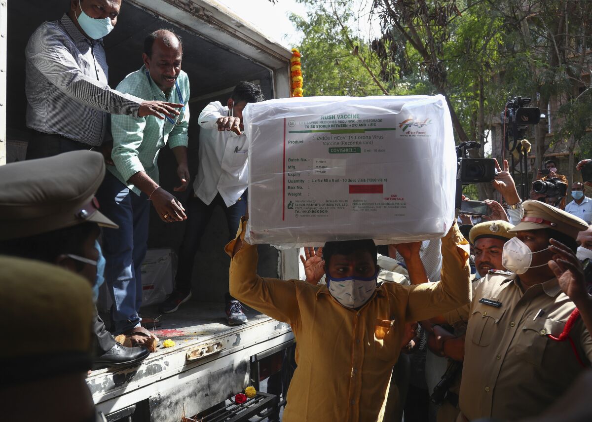 Health workers shift a box containing COVID-19 vaccine from a vehicle to a cold storage at Commissionerate of Health and Family Welfare in Hyderabad, India, Tuesday, Jan. 12, 2021. On Jan. 16 India will start the massive undertaking of inoculating an estimated 30 million doctors, nurses and other front line workers, before attention turns to around 270 million people who are either aged over 50 or have co-morbidities. (AP Photo/Mahesh Kumar A.)