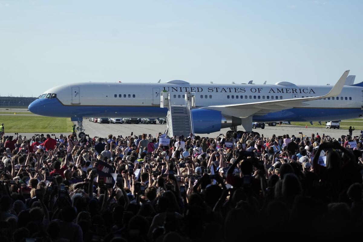 A crowd stands near Air Force Two as they wait for Democratic candidates to debark for a rally in Romulus, Mich.