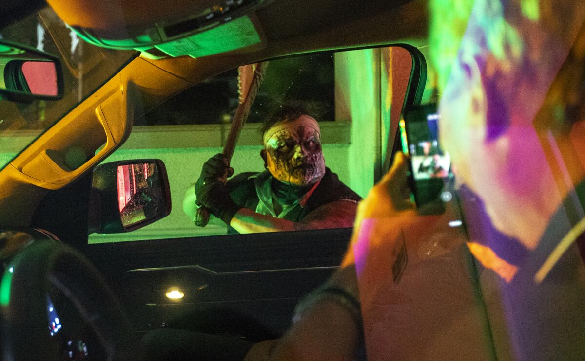 Guests take pictures of an character at the "Tunnel of Terror Haunted Car Wash."