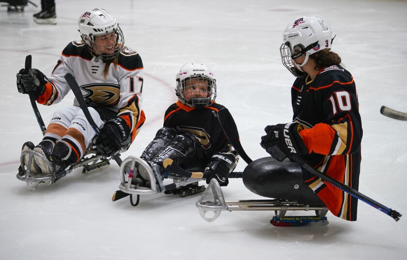 Sarah Bettencourt (left) and Paralympian Lera Doederlein (right), work with Andrew Kane, 5, during Try Sled Hockey clinic.