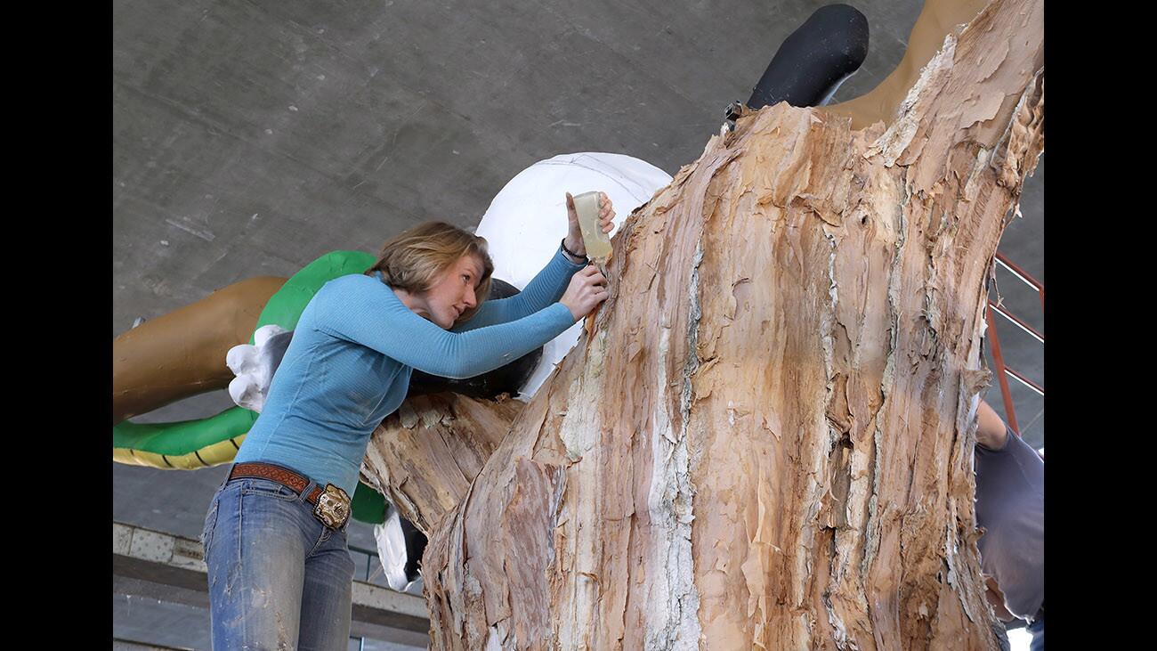 Decorating crew chief Hannah Ward carefully places glue and paperbark, from the Melaleuca tree, on the central part of the La CaÃ±ada Flintridge Float Association Panda-Monium float, during construction at the Flintridge Prep parking lot in La CaÃ±ada Flintridge on Wednesday, Dec. 27, 2017.