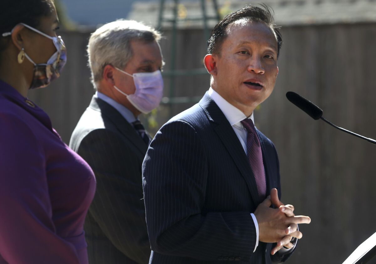 FILE - San Francisco City Attorney David Chiu, right, stands next to Mayor London Breed, left, and former City Attorney Dennis Herrera as he speaks during a news conference on Sept. 29, 2021 in San Francisco. Residents of some of San Francisco's most popular and troubled neighborhoods are electing a new state legislative assembly member in a special runoff race Tuesday, April 19, 2022 between two Democrats. The runoff is being held because neither Matt Haney nor David Campos received more than 50% of the vote in February's special election. (Lea Suzuki/San Francisco Chronicle via AP, File)