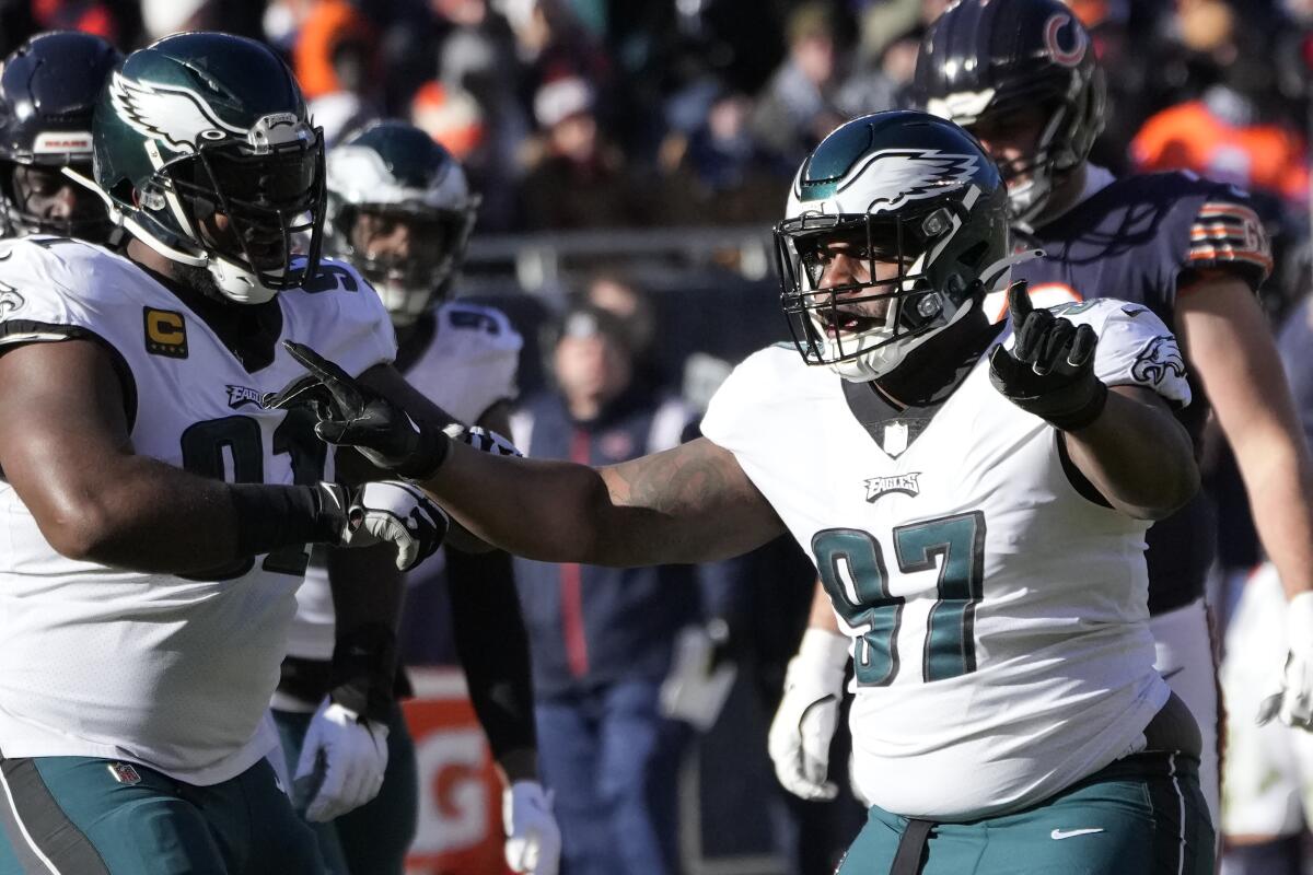 Philadelphia Eagles' Fletcher Cox and Javon Hargrave celebrate Hargrave's sack of Chicago Bears quarterback Justin Fields.