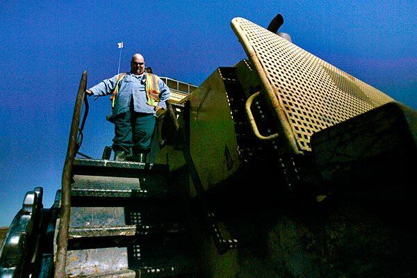 Mike Speiser climbs down from his bulldozer for a lunch break after churning over mounds of garbage at the Puente Hills Landfill, one of the largest such facilities in the nation. Nearly 4 million tons of junk and muck, one-third of Los Angeles County's trash, is added to this man-made mountain each year.