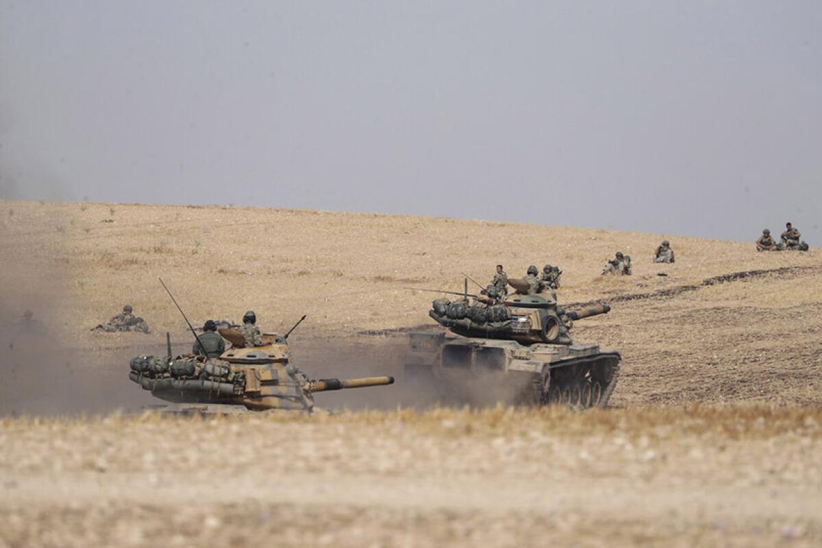 Turkish tanks and troops approach the Syrian town of Manbij on Tuesday.
