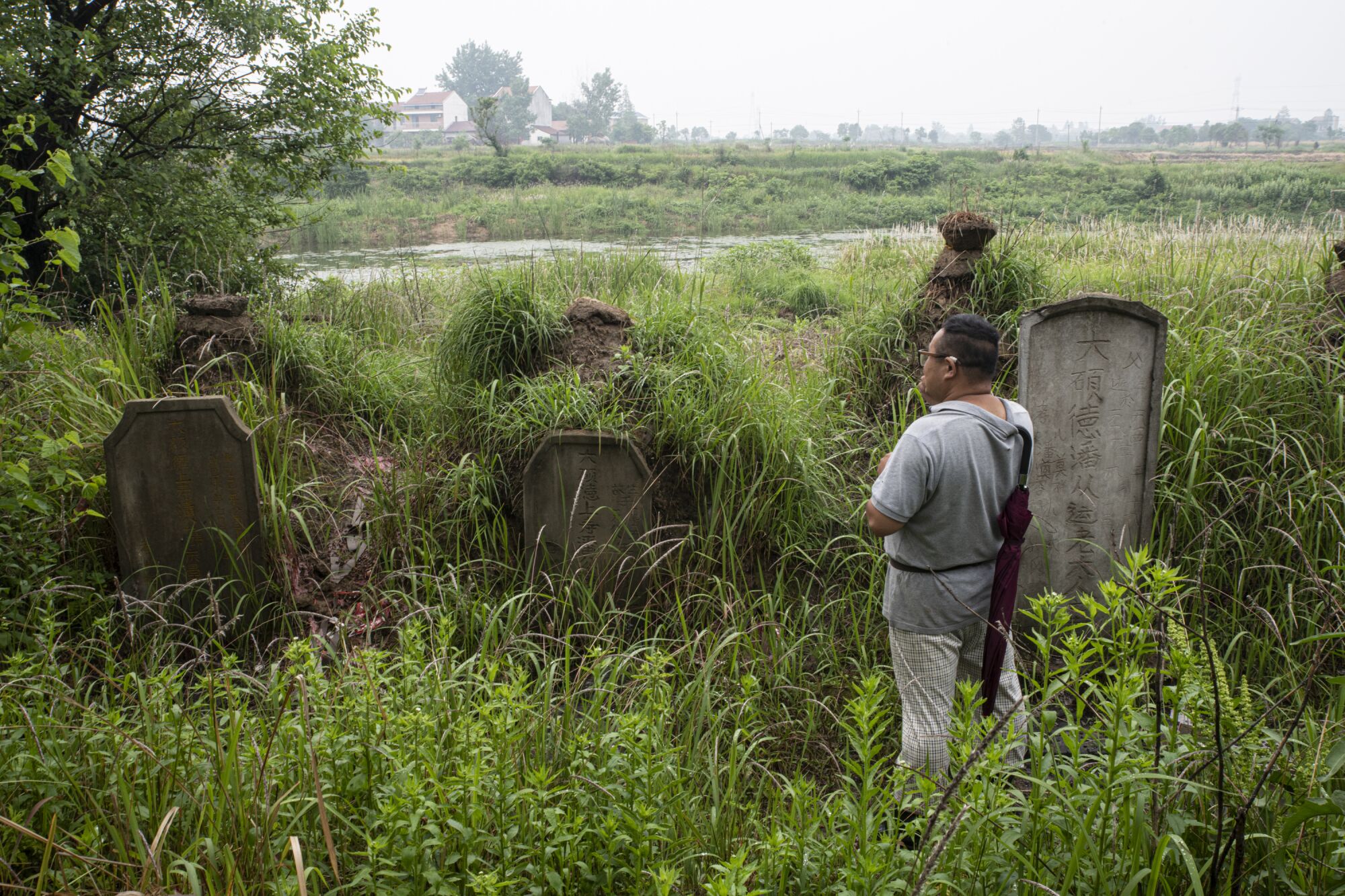 Pan Bangfeng looks at his ancestors' graves on what was once a plot of family farmland.