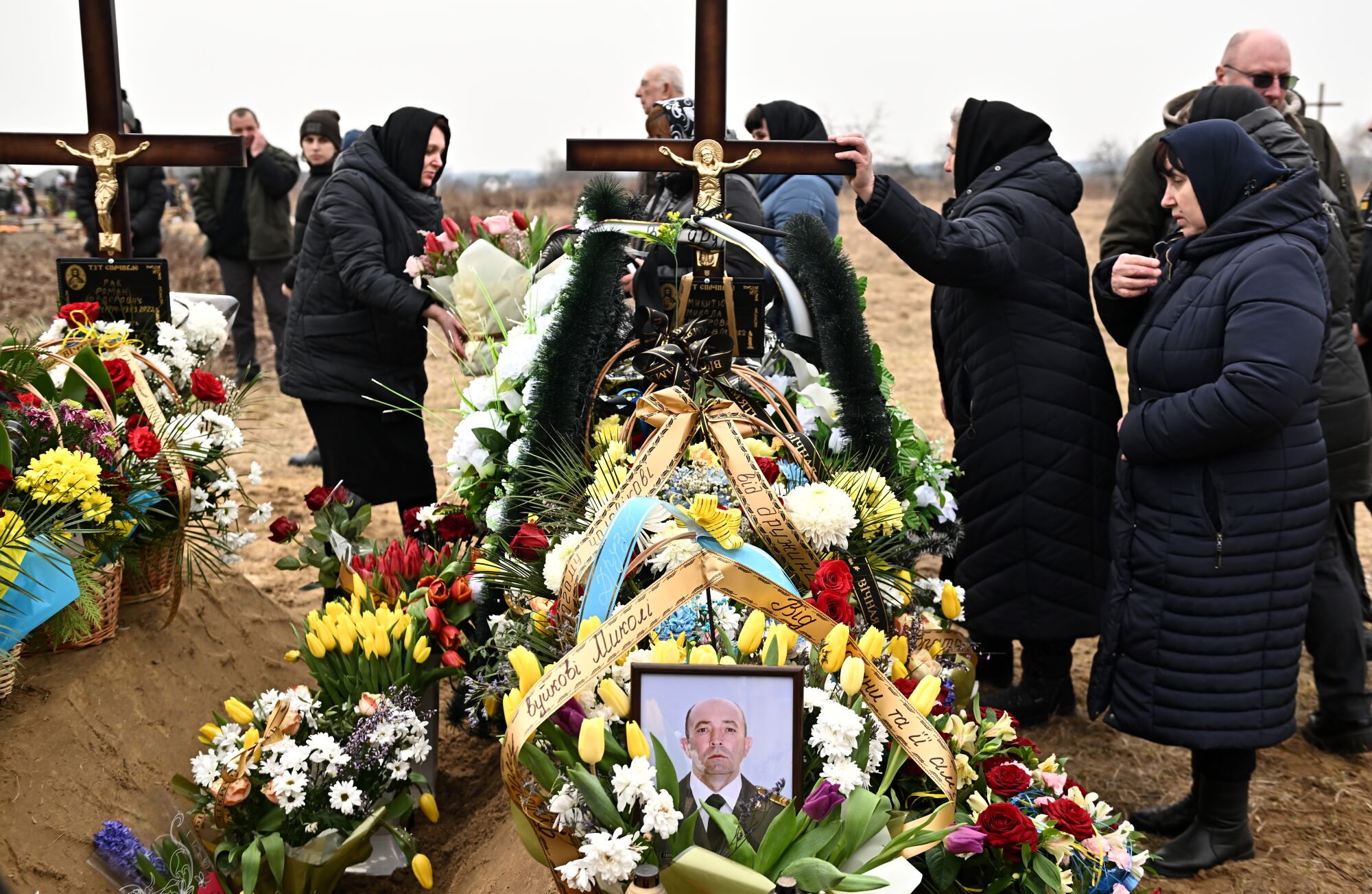 People surround a fresh grave.