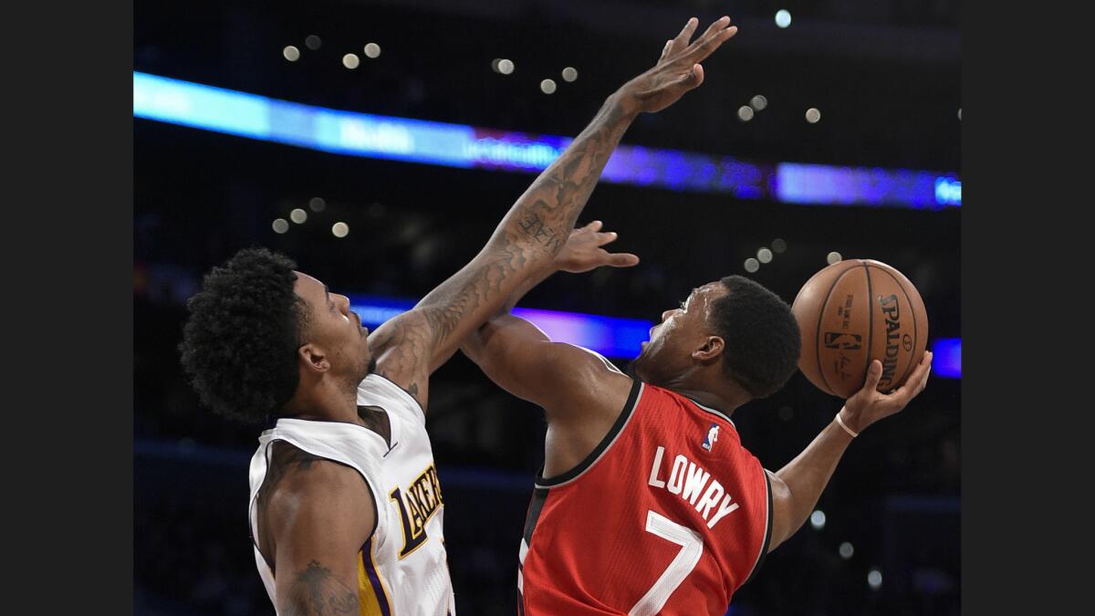 Lakers guard Nick Young challenges a shot by Raptors guard Kyle Lowry during the first half.