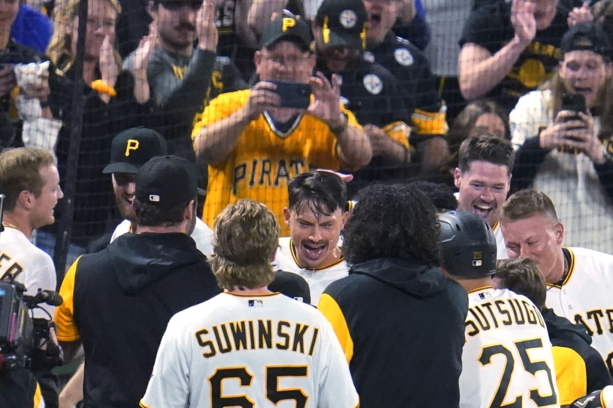 Bryan Reynolds, center, celebrates after driving in the winning run for the Pirates 