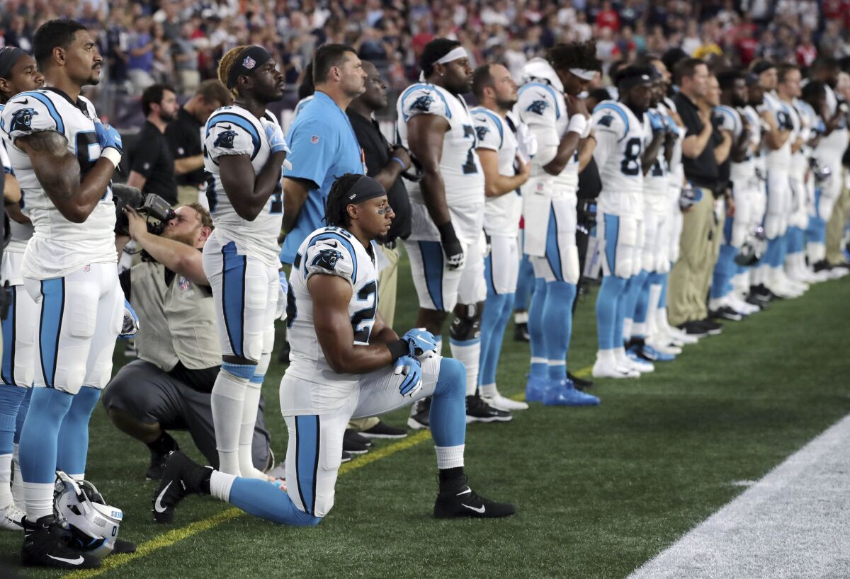 FILE - In this Aug. 22, 2019, file photo, Carolina Panthers strong safety Eric Reid (25) kneels during the national anthem before the team's NFL preseason football game against the New England Patriots in Foxborough, Mass. Despite setting two defensive franchise records for the Panthers last season, Reid remains unsigned like his close friend Colin Kaepernick. Washington coach Ron Rivera, Reid’s former coach in Carolina, gave him a strong endorsement Wednesday, Sept. 16. “I would tell them he’s a heckuva teammate,” Rivera said. "He came in and the young man did exactly what was asked of him." (AP Photo/Charles Krupa, File)