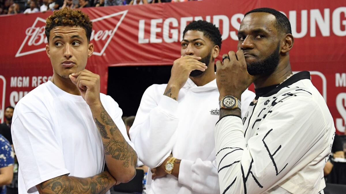 Lakers teammates (from left) Kyle Kuzma, Anthony Davis and LeBron James talk before the start of a summer league game against the Clippers at Thomas & Mack Center in Las Vegas on Saturday. They're very much on the same page, judging from the outfits and hand gestures.
