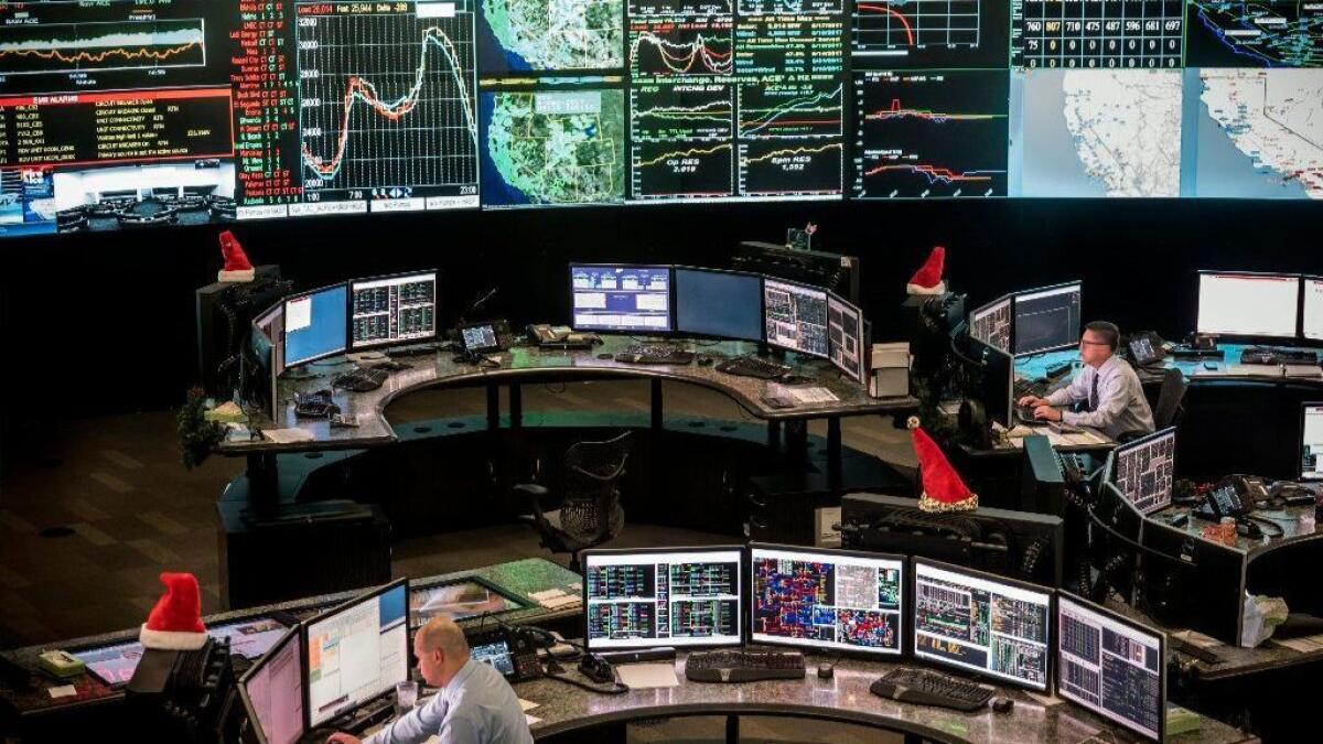 Workers in the CAISO control center monitor energy levels and prices across the California electrical grid. A plan to expand the grid to as many as 14 states is generating praise and criticism.