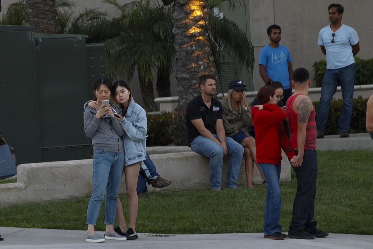 A crowd gathers at Golden Haven Drive and Judicial Drive in University City after a gunman shot seven victims at the La Jolla Crossroads Apartment complex. (Nelvin C. Cepeda / San Diego Union-Tribune)