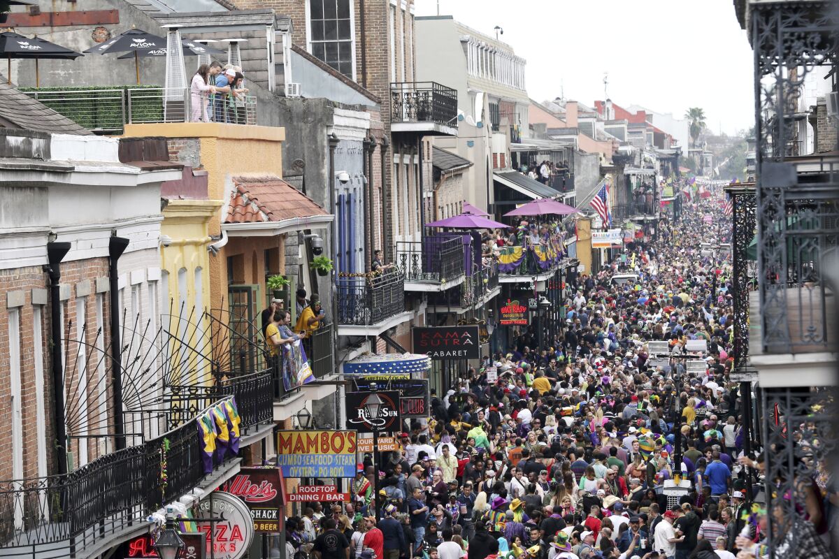 FILE - In this Feb. 25, 2020, file photo, crowds are seen packing Bourbon Street on Mardi Gras day in New Orleans. New Orleans will reinstitute an indoor mask mandate to fight the spread of COVID-19 while readying for an influx of visitors for the Mardi Gras season, the city health director said Tuesday, Jan. 11, 2022. Dr. Jennifer Avegno said the mandate takes effect Wednesday at 6 a.m. and will apply to participants in the annual Mardi Gras balls that take place in the city. (AP Photo/Rusty Costanza, File)