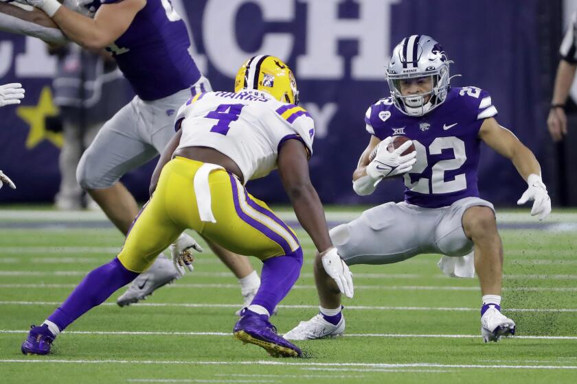 LSU safety Todd Harris Jr. (4) causes Kansas State running back Deuce Vaughn (22) to stop and turn during the first half of the Texas Bowl NCAA college football game Tuesday, Jan. 4, 2022, in Houston. (AP Photo/Michael Wyke)