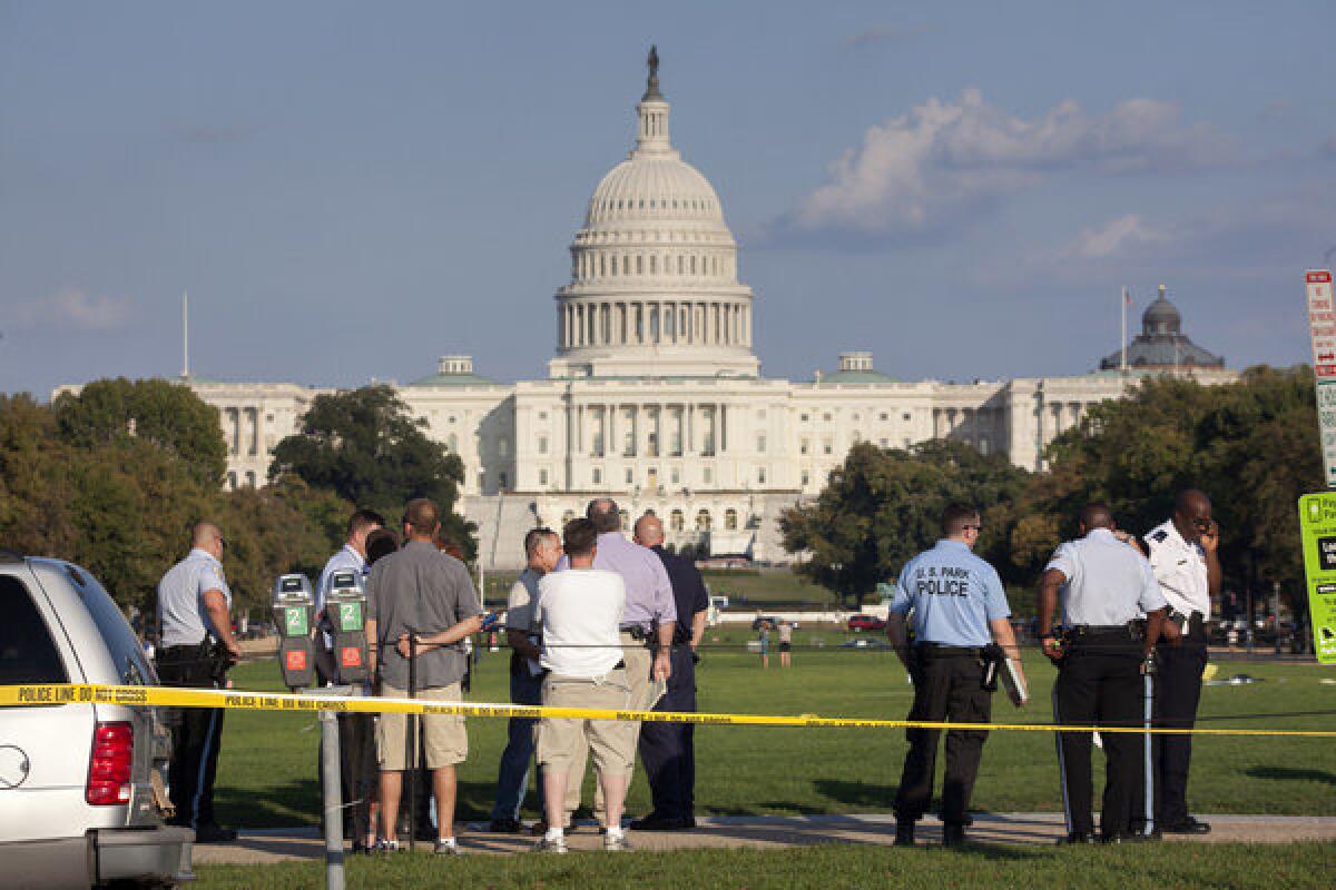 Law enforcement officers are near the scene on the National Mall in Washington, where, according to a fire official, a man set himself on fire Friday. The official said the man was flown by helicopter to a hospital.