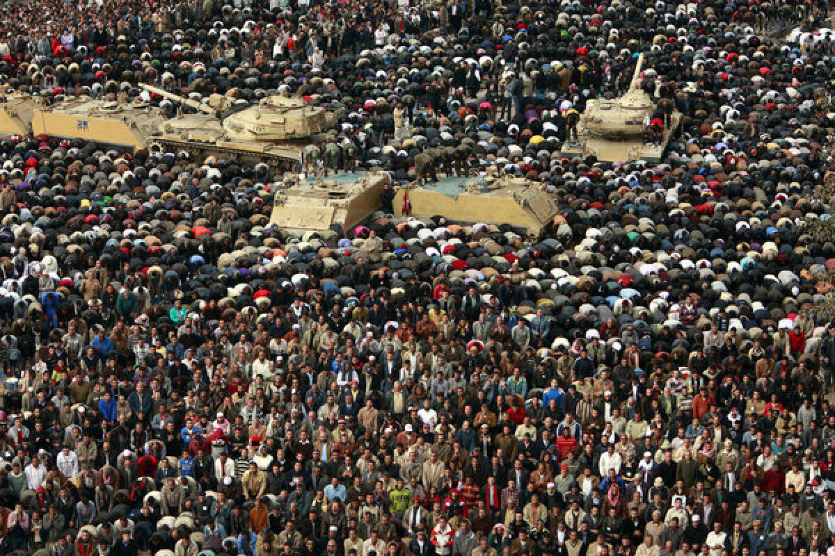 Members of the Egyptian army pray with protesters in Cairo's Tahrir Square on Feb. 11, 2011, the day that President Hosni Mubarak bowed to popular pressure and agreed to step down. In 2011, youth-driven uprisings toppled autocratic regimes in Tunisia, Egypt and Libya.