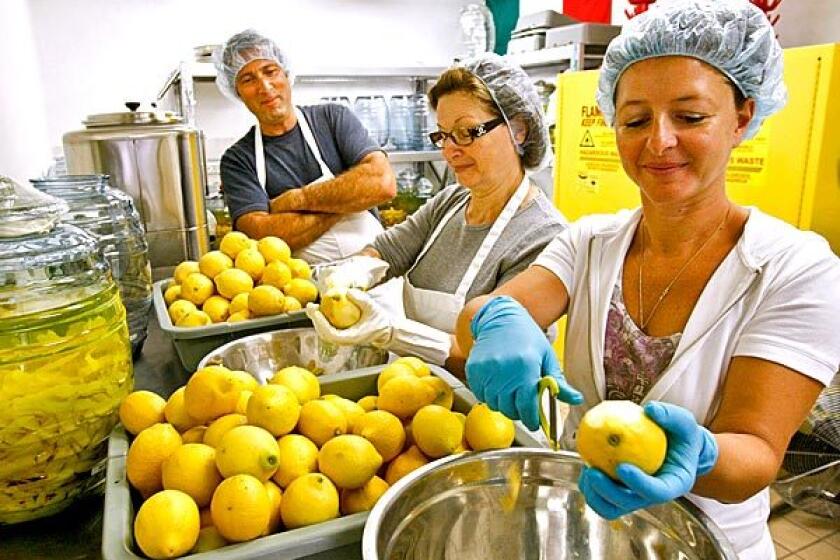 Rossana Zaretti, center, and daughter Manuela Zaretti-Carling, with Manuela's husband, Ventura Limoncello co-owner James Carling, peel lemons for limoncello.