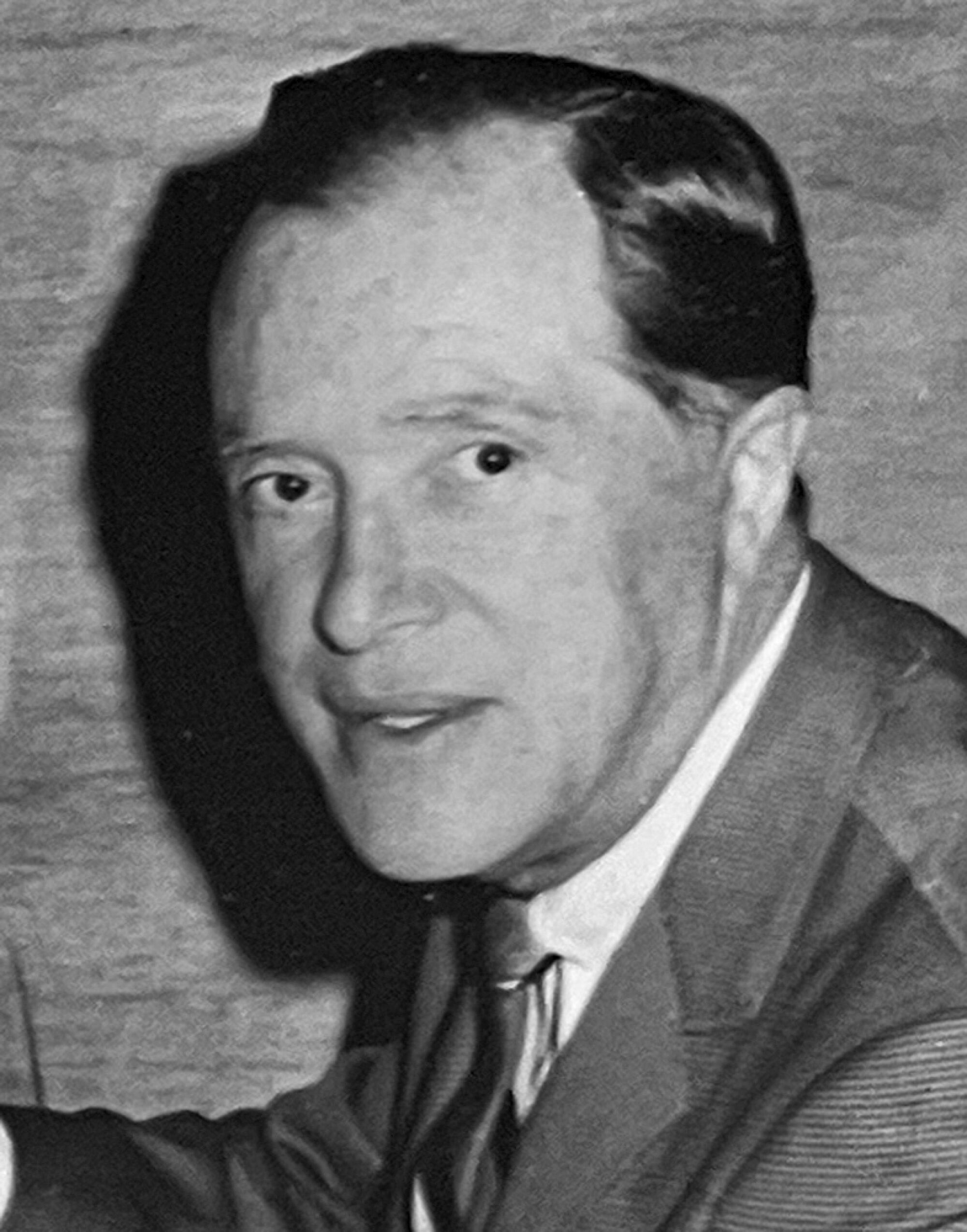 black and white headshot of a man in suit and tie
