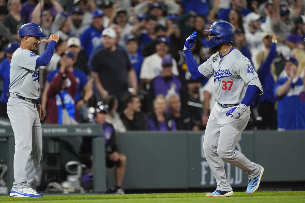 Teoscar Hernández gestures to third base coach Dino Ebel while running the bases after his three-run homer in the ninth