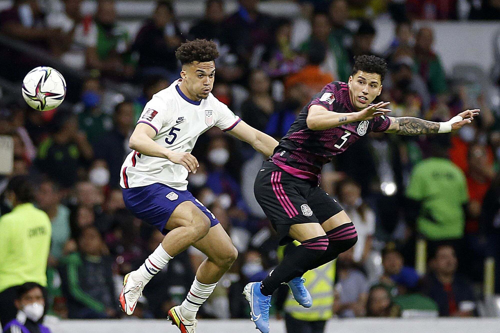 U.S. defender Antonee Robinson, left, and Mexico defender Jorge Sanchez jump for the ball.