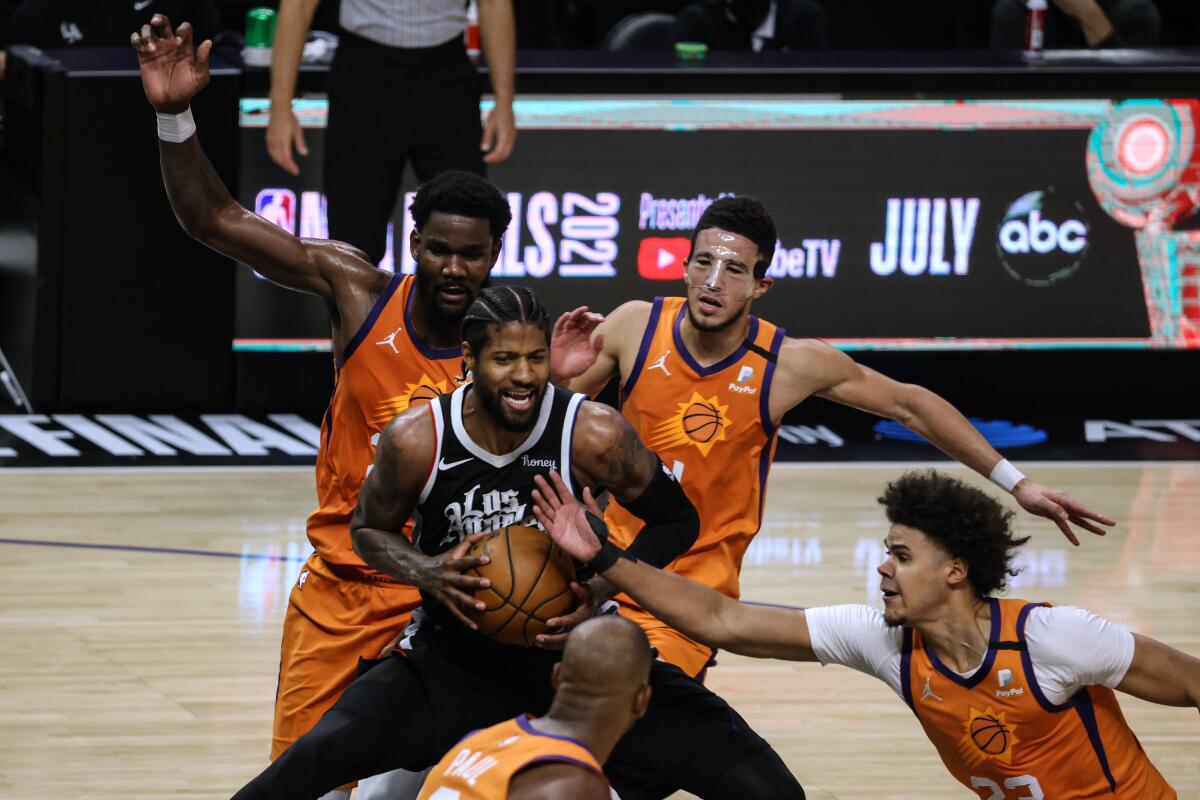 The Clippers' Paul George is surrounded by Phoenix Suns defenders in Game 3 of the Western Conference finals.