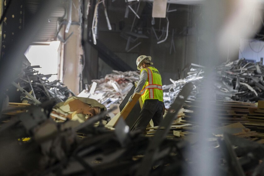 A worker sorts through debris while crews demolish the interior of the old Nordstrom building. The mall is being transformed into a mixed-use office campus.