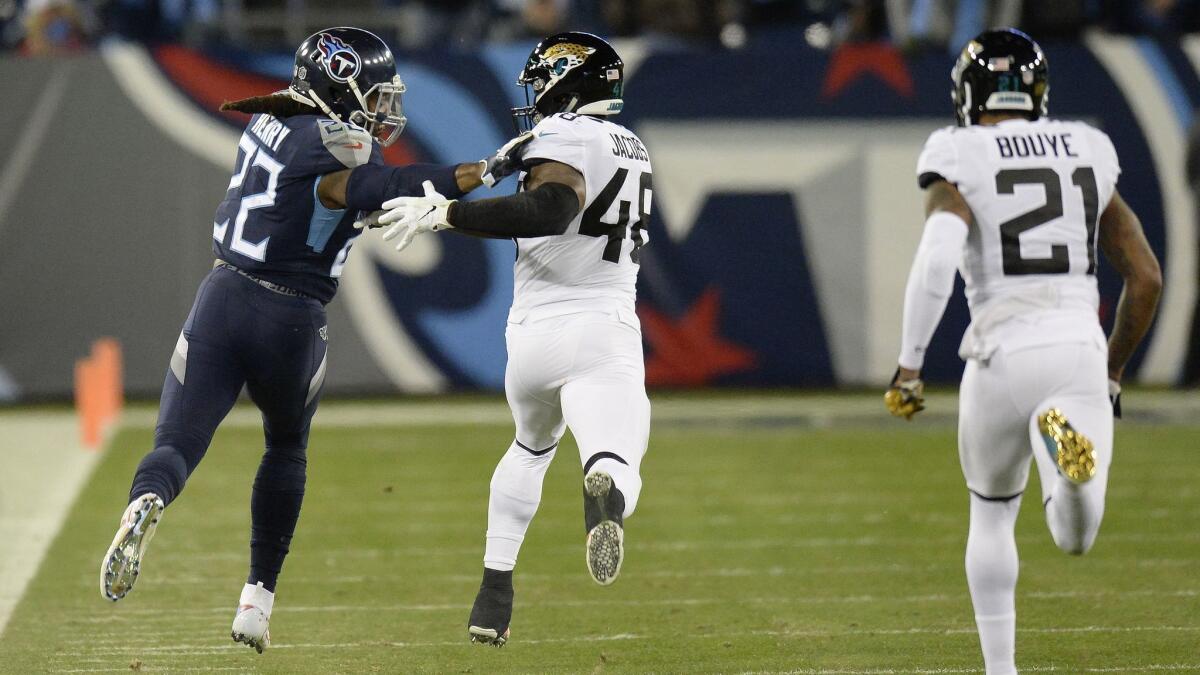 Tennessee Titans running back Derrick Henry (22) runs past Jacksonville Jaguars outside linebacker Leon Jacobs (48) for a touchdown during the first half.