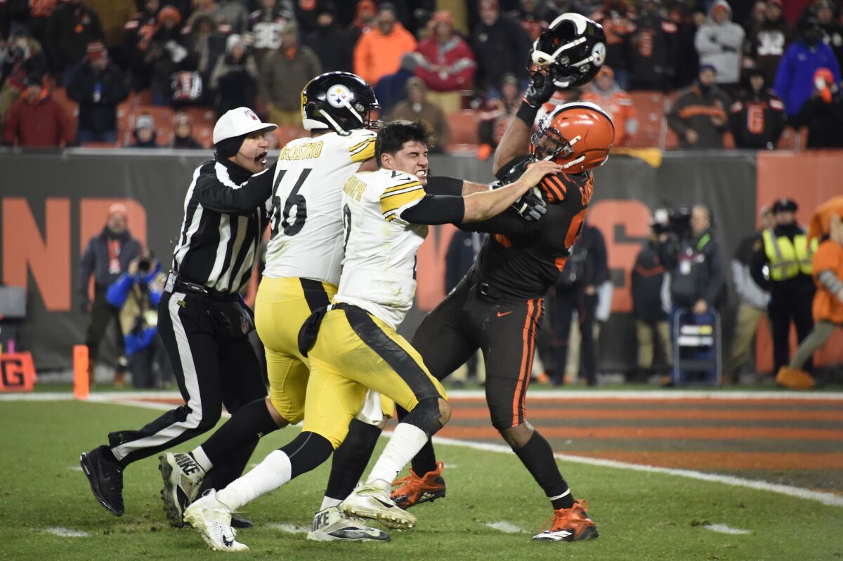 Browns defensive end Myles Garrett, right, fights with Pittsburgh Steelers quarterback Mason Rudolph.