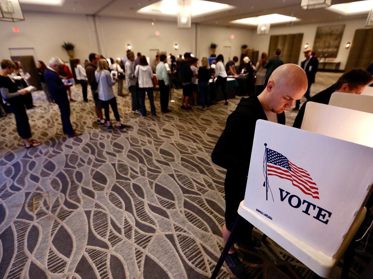 Luke Hallberg casting his ballot as a line forms at the Luxe Sunset Boulevard Hotel polling station in Brentwood.