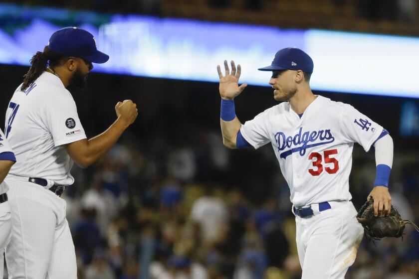 Los Angeles Dodgers right fielder Cody Bellinger, right, celebrates after their 7-5 win against the Tampa Bay Rays with relief pitcher Kenley Jansen after a baseball game in Los Angeles, Tuesday, Sept. 17, 2019. (AP Photo/Chris Carlson)