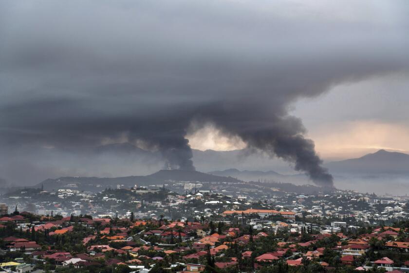 Smoke rises during protests in Noumea, New Caledonia, Wednesday May 15, 2024. France has imposed a state of emergency in the French Pacific territory of New Caledonia. The measures imposed on Wednesday for at least 12 days boost security forces' powers to quell deadly unrest that has left four people dead, erupting after protests over voting reforms. (AP Photo/Nicolas Job)