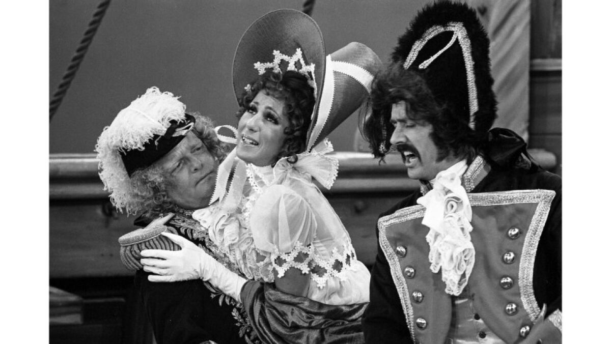 Three actors in costume perform a comedy sketch.