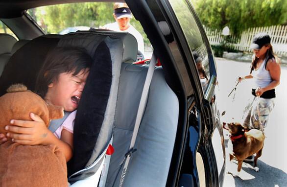 A scared Alexis Faieta cries in the back seat of the family vehicle as her parents, April and John Faieta, prepare to evacuate from Haines Canyon Avenue in Tujunga on Monday.