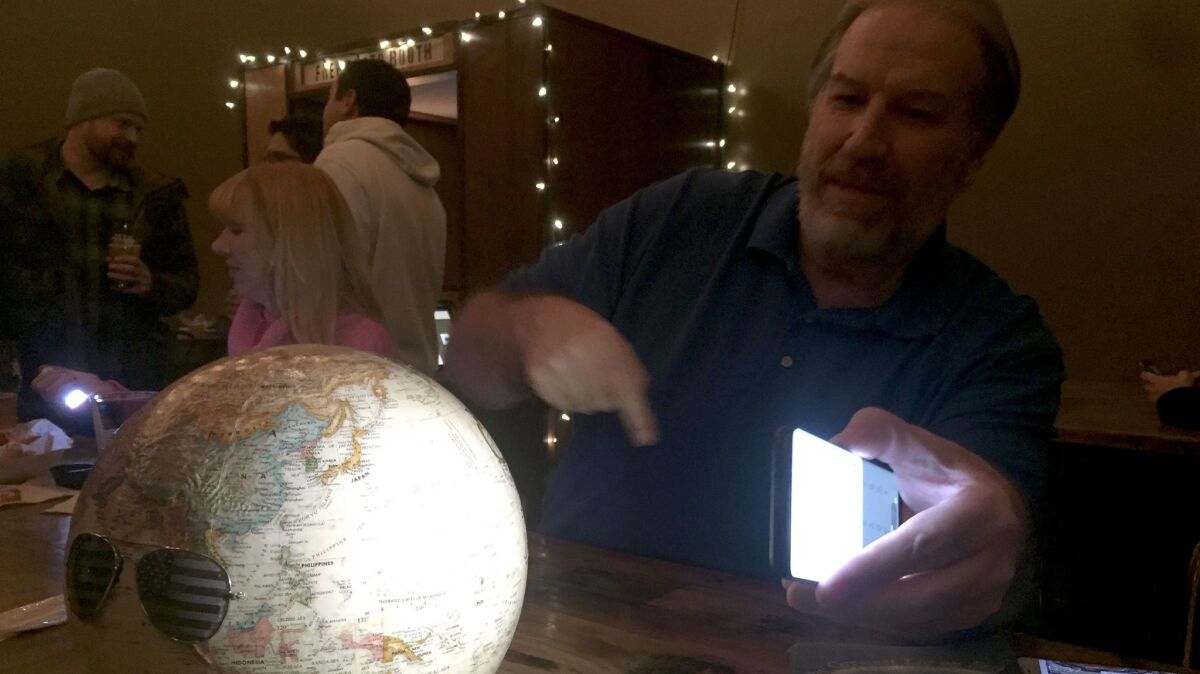 Bob Knodel, host of Globebusters channel on YouTube, who believes Earth is flat, tries to prove it with a globe at a flat Earth meeting in Golden, Colo.