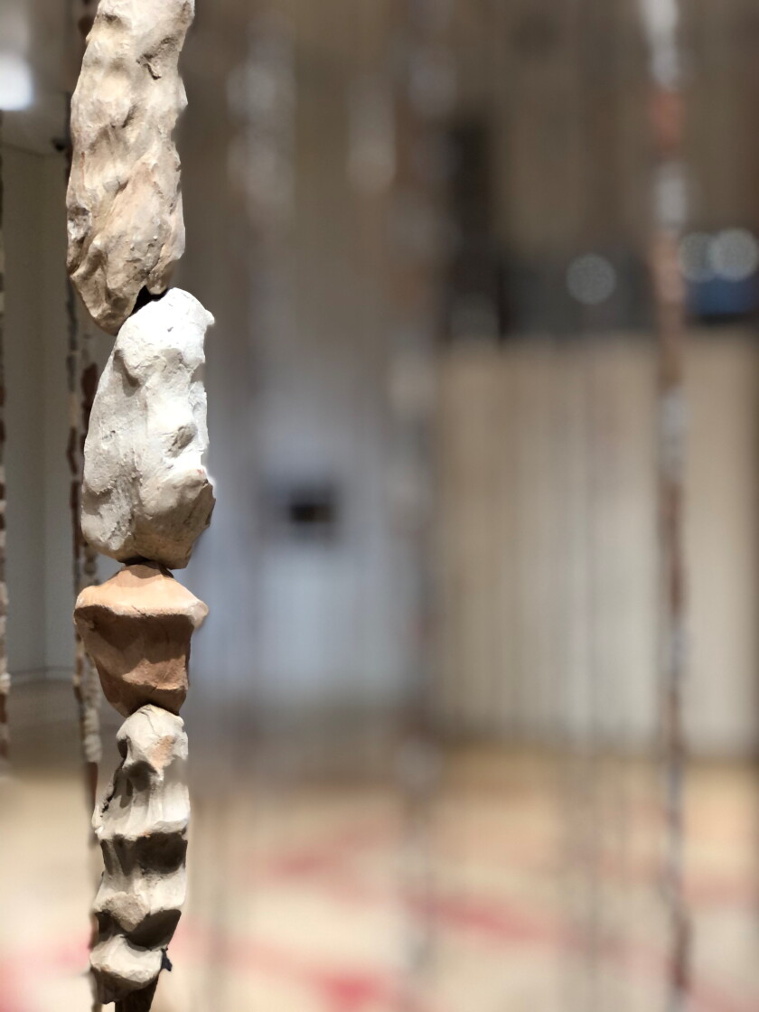 Clay beads bearing the imprint of a human hand are seen in close-up
