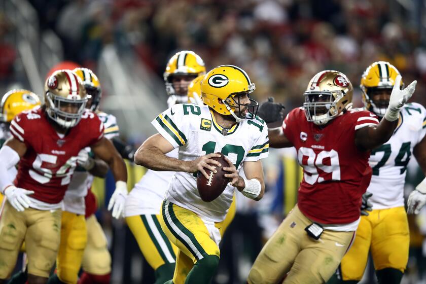Packers quarterback Aaron Rodgers scrambles from the 49ers pass rush during a game Nov. 24, 2019, at Levi's Stadium in Santa Clara.