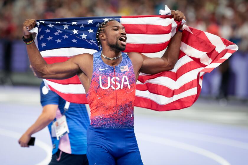 American Noah Lyles celebrates after winning the men's 100-meter final at the 2024 Paris Olympics at Stade de France