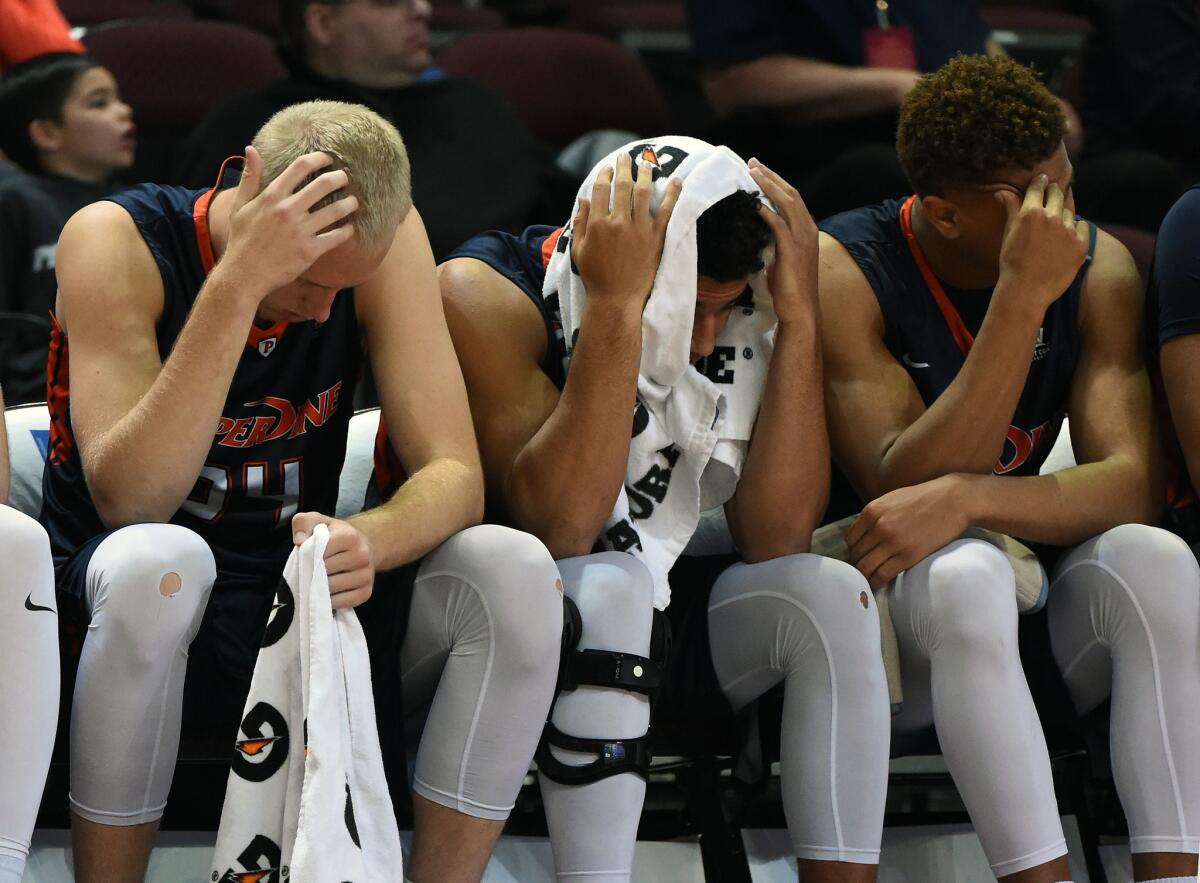 Pepperdine players Jake Johnson (34), Jonathan Allen (23) and Kameron Edwards (13) react on the bench late in their 81-66 loss to Saint Mary's in the West Coast Conference tournament.